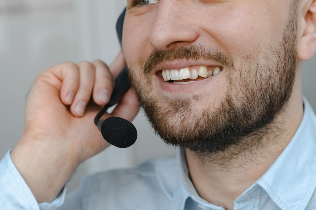 Gros plan d'un agent d'assistance à la clientèle souriant portant un micro-casque.