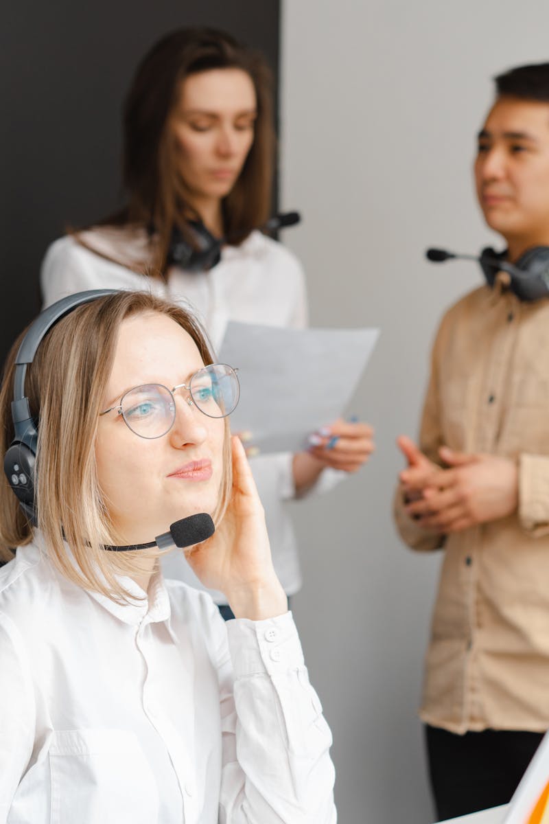 Équipe de professionnels dans un centre d'appel discutant de stratégies de service à la clientèle tout en portant des écouteurs.