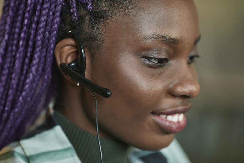 Gros plan d'un employé heureux d'un centre d'appel portant un casque et souriant tout en travaillant.